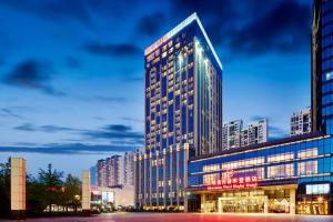 a tall building with many windows in a city at Sheraton Wuxi Binhu Hotel in Wuxi