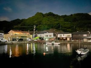 a body of water with boats in a harbor at 浪漫宿花町 in Mitarai