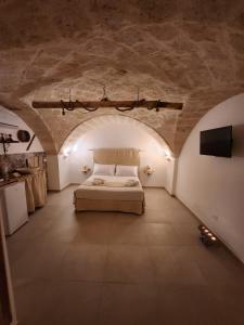 um quarto com uma cama num quarto com um tecto de pedra em Nene' em Fasano