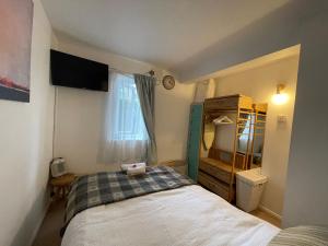- une petite chambre avec un lit et une fenêtre dans l'établissement Grundy House, à Uxbridge