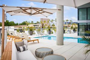 patio z krzesłami, basenem i parasolem w obiekcie AC Hotel by Marriott Irvine w mieście Irvine