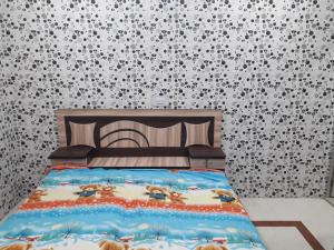 a bedroom with a bed with a patterned wall at Chabbra niwas kanpur in Kānpur