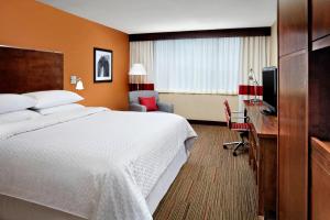 a hotel room with a large bed and a desk at Four Points by Sheraton Halifax in Halifax