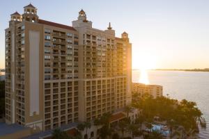 薩拉索塔的住宿－The Ritz-Carlton, Sarasota，水边一座大建筑的 ⁇ 染