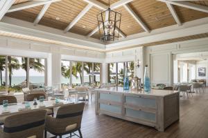 a living room with tables and chairs and the ocean at The Ritz-Carlton, Sarasota in Sarasota