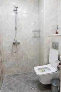 y baño con aseo blanco y ducha. en Alagen Apartments Burgas en Burgas