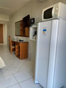 a kitchen with a white refrigerator and a table at Flat Centro de Brasília - Garvey Park Hotel in Brasilia