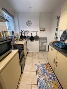 a kitchen with a stove and a tile floor at Grundy House in Uxbridge