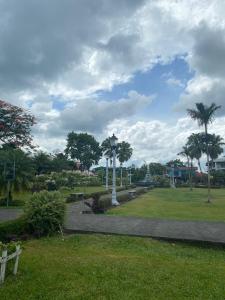 a park with palm trees and a pathway at coati del arenal posada in Fortuna