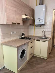 a kitchen with a washing machine and a sink at apartments of Saint Theodore in Lviv