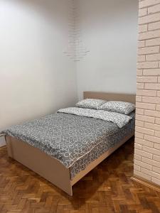 a bed in a bedroom with a white wall at apartments of Saint Theodore in Lviv