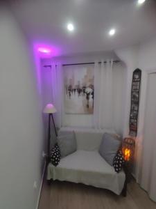 a living room with a white couch and a purple light at Paul's studios in Thessaloniki