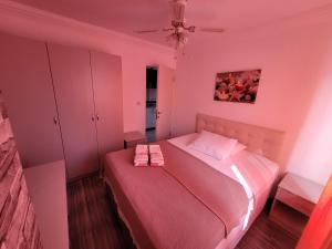 a pink bedroom with a bed with two towels on it at Apsa Butik Hotel in Sukhum