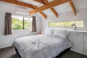 Un dormitorio con una cama grande y una ventana en Mapua Fernz en Mapua