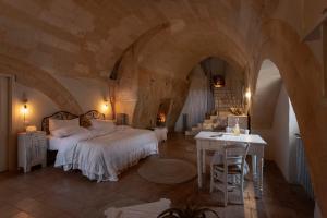 a bedroom with a bed and a table and chairs at Corte San Leonardo in Matera