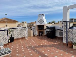 patio z grillem i kuchenką na dachu w obiekcie Holiday home with large roof terrace near La Mata beach w mieście Torrevieja