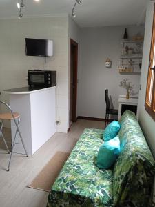 a living room with a couch with blue pillows at Estudio acogedor cercano Santander y próximo al aeropuerto in Maliaño