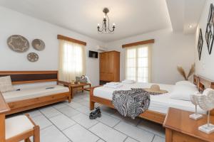 una camera con due letti e un lampadario a braccio di Summer Memories Studios a Naxos Chora