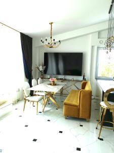 a living room with a table and chairs and a tv at Luxury Penthouse with Large Terrace & Panoramic Old Town View in Vilnius
