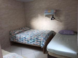 Dormitorio pequeño con 2 camas y lámpara en Casa Temporada en Serra