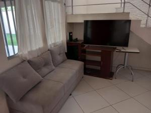 sala de estar con sofá y TV de pantalla plana en Casa Temporada en Serra