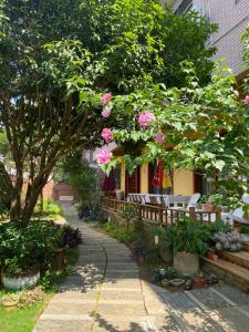 a garden with benches and trees and pink flowers at YangShuo Eden Inn in Yangshuo