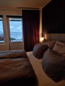 a hotel room with two beds and a window at Apartments with parking and terrace in Ålesund