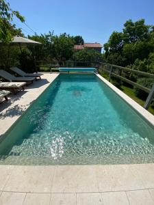 a swimming pool with blue water in a backyard at Wellness House Oliva with heated salt water Pool, Sauna & Jakuzzi in Labin
