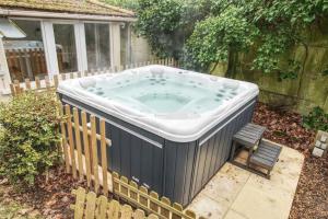 a hot tub in a yard with a chair at Maison avec jardin et jacuzzi proche Polytechnique in Palaiseau