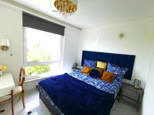 sypialnia z niebieskim łóżkiem i oknem w obiekcie Luxury Penthouse with Large Terrace & Panoramic Old Town View w Wilnie