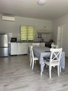 a kitchen with a table and chairs and a refrigerator at Agroger Üdülő in Balatonudvari