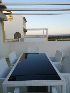 a table and chairs on top of a house at Apartamento Sol e Mar in Vila Nova de Cacela