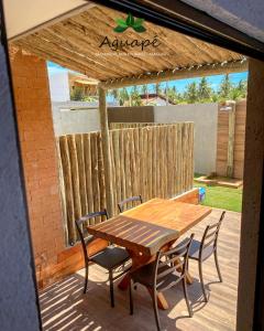 a wooden table and chairs on a patio at Milagres Aguapé Beach House in São Miguel dos Milagres