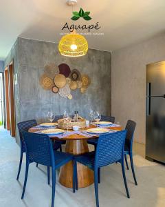 a dining room with a table and blue chairs at Milagres Aguapé Beach House in São Miguel dos Milagres