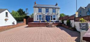 a house with a brick driveway in front of it at Lamack Vale House, Tenby, 5 Bedrooms with Private Heated Indoor Swimming Pool & Parking in Tenby