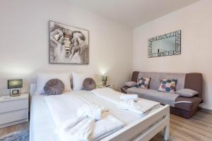 a bedroom with a large bed and a couch at Viktorija 1BR Apartment in Zadar