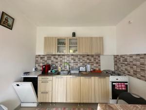 a small kitchen with wooden cabinets and a stove at Fortuna Vendégház in Egerszalók