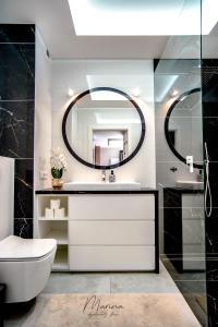 a bathroom with a sink and a mirror at Marina Apartament 13 Iława - z prywatnym miejscem parkingowym in Iława