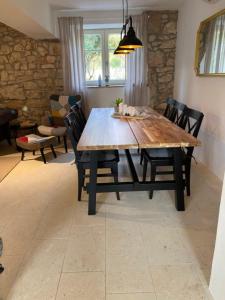 een eetkamer met een houten tafel en stoelen bij Wellness House Oliva with heated salt water Pool, Sauna & Jakuzzi in Labin