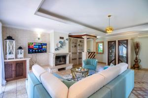 a living room with a blue couch and a fireplace at Villa Iris in Galé