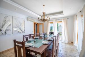 a dining room with a long table and chairs at Villa Iris in Galé