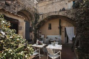 an outdoor patio with tables and chairs in a building at Corte San Leonardo in Matera