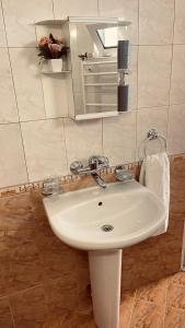 W łazience znajduje się biała umywalka i lustro. w obiekcie Къща за гости Загорски w mieście Kałofer