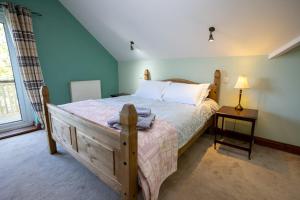 a bedroom with a bed and a lamp on a table at Lamack Vale House, Tenby, 5 Bedrooms with Private Heated Indoor Swimming Pool & Parking in Tenby +37 photos