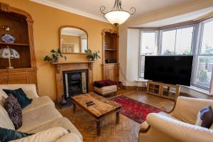 a living room with a fireplace and a flat screen tv at 5 Bedroom Holiday Home With Spa Now Available in Tenby