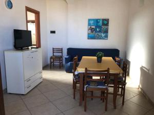 a living room with a table and chairs and a tv at White House in Tre Fontane +10 photos