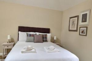 a bedroom with a large white bed with towels on it at Birchwood Bothy in Pitlochry