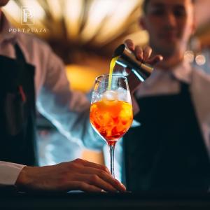 a bartender is pouring a drink into a glass at Port Plaza YVN in Pʼarakʼar