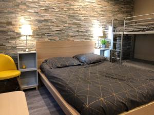 um quarto com uma cama e uma parede de tijolos em Hotel Caplandes em Capbreton
