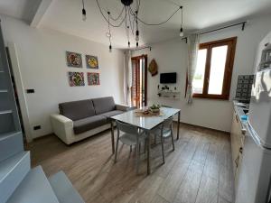 a kitchen and living room with a table and a couch at sicily home casa vacanze con piscina in San Vito lo Capo